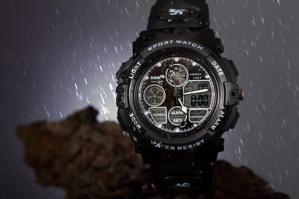Black wristwatch shown on rainy background