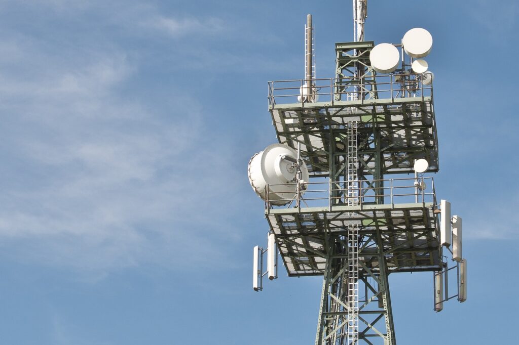 Radio tower with multiple dishes against a blue sky background