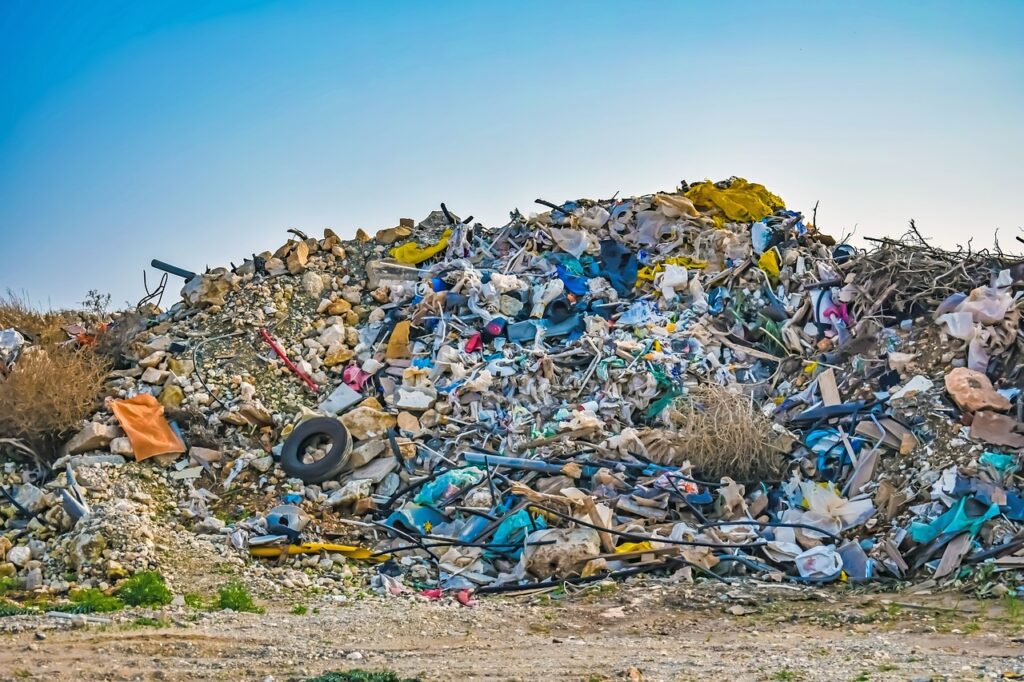 image of garbage piled in a landfill under a blue sky